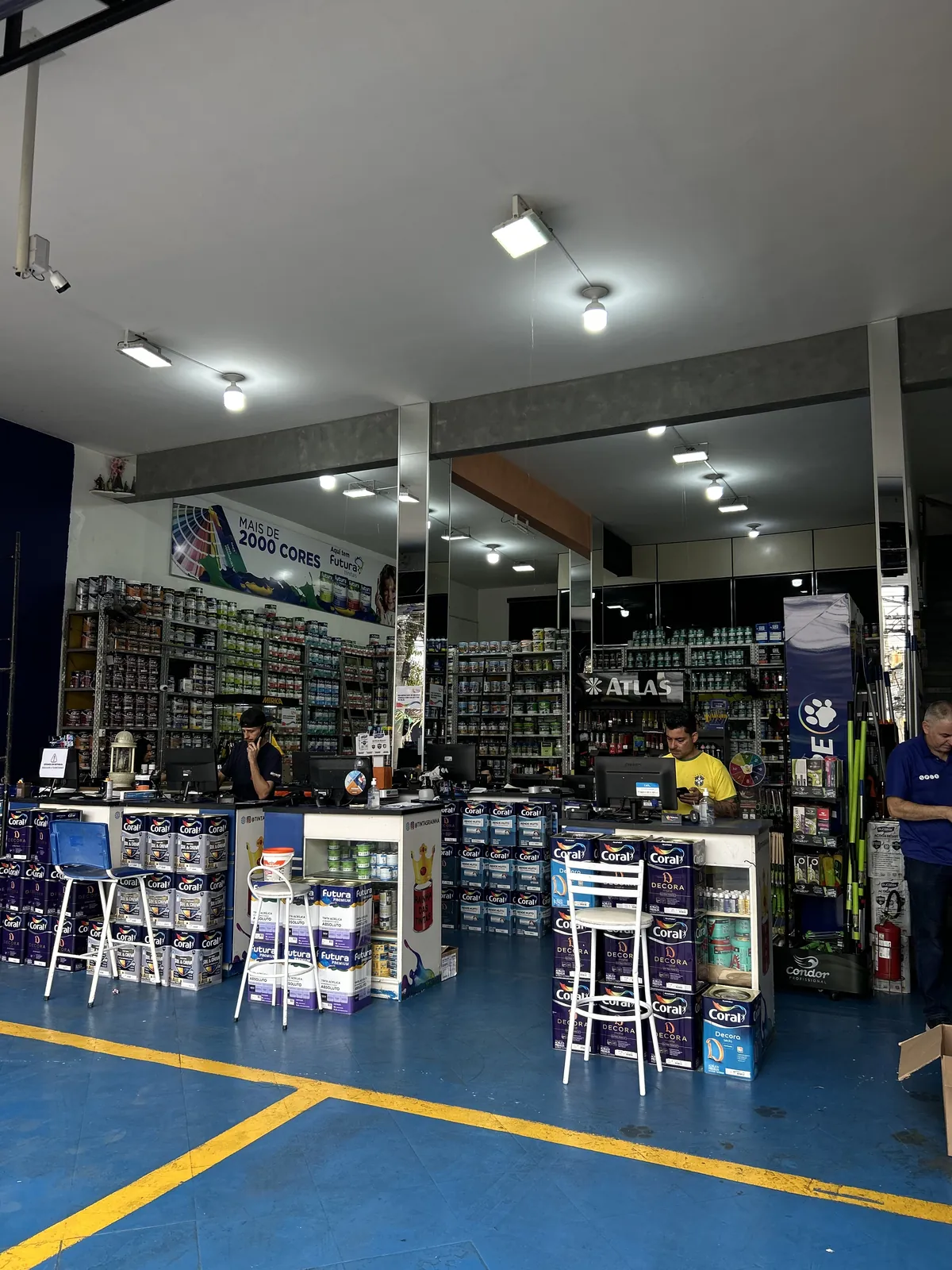 Interior da loja Tintas Rainha com amplo estoque de tintas